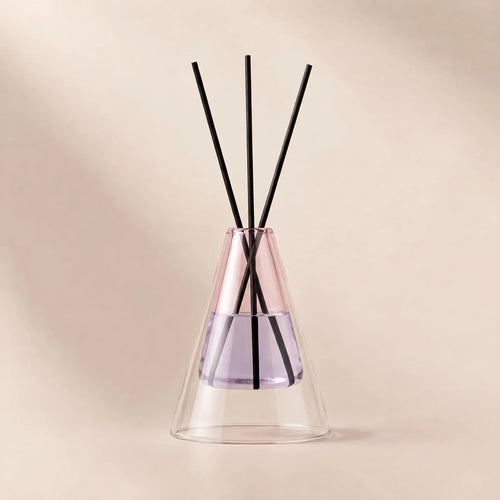 Cone shaped reed diffuser in pale pink glass with black reeds